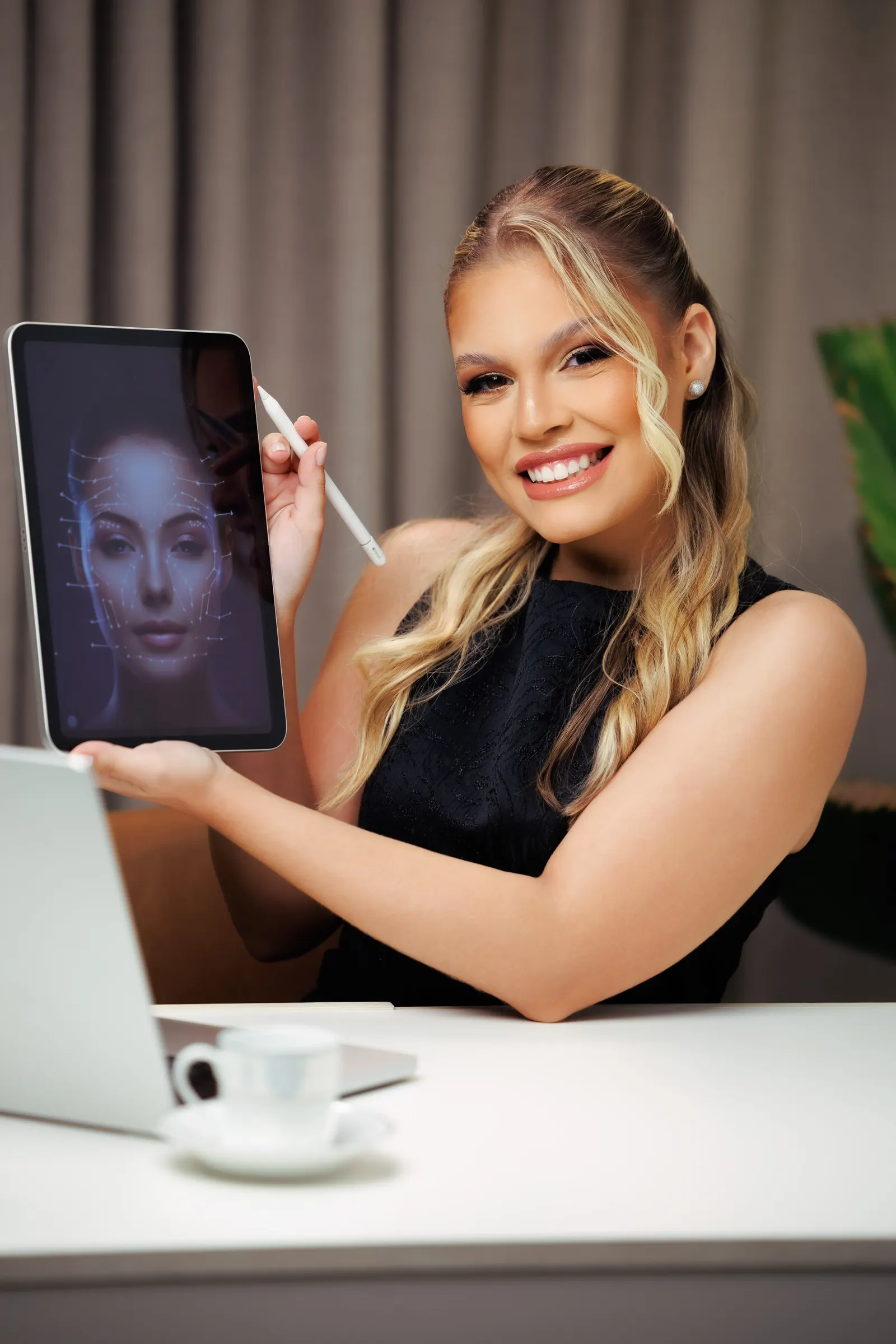 Dra. Letícia Marques sorrindo, mostrando no tablet a análise das proporções de um rosto